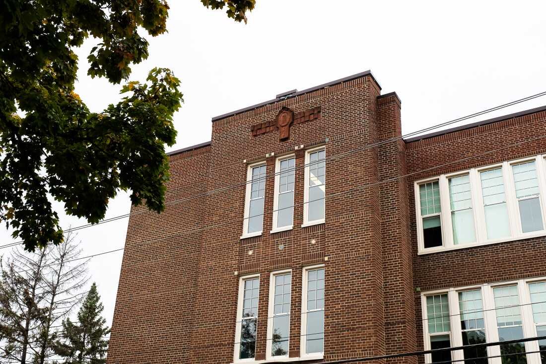 This photo shows the exterior of Journeys Secondary School in St. Paul. It is a brown-brick multistory building with white-framed windows.