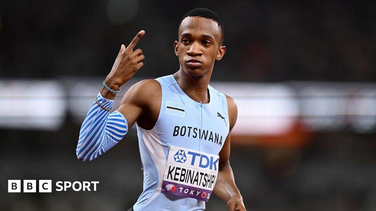 Collen Kebinatshipi shown from waist up wearing a Botswana sky blue sleeveless running jersey with his name written on a bib on the stomach, looks to his right while pointing his right index finger skywards as he prepares to compete in the men's 400m at the World Athletics Championships in Tokyo