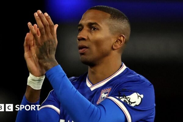 Former England defender Ashley Young in a blue Ipswich Town shirt, clapping his hands