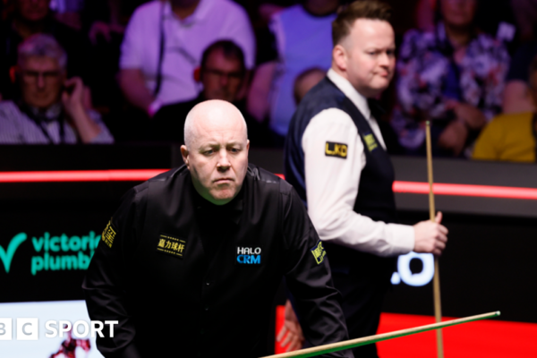 John Higgins eyes a shot