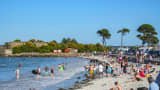 Tourists and vacationers sit and lie on their towels on the beach, others play and swim in the English Channel in Saint Pol de Leon, France.