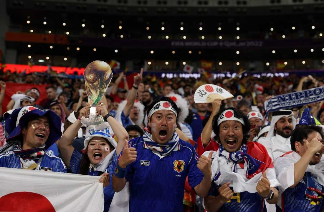 Japan supporters celebrate after their team beat Spain at a 2022 World Cup game held at the Khalifa International Stadium in Doha, Qatar, on Dec. 1, 2022.