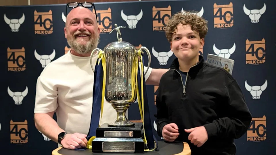 Neil McManus and a young child standing next to Oxford United's Milk Cup.