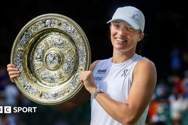 Iga Swiatek holding the Wimbledon women's singles final trophy