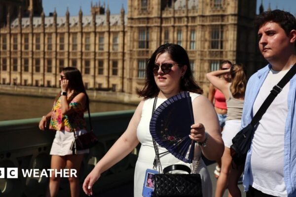 People looking hot in the sunshine with the Houses of Parliament in the background