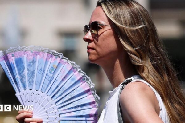 A pupil is sprayed with a fine mist as they drink water at the Harris Academy Primary Maxyflower school, as Britain experiences record temperatures disrupting schools and transport networks, in Grays, Britain, June 24, 2026.