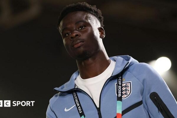 Bukayo Saka in a pale blue England tracksuit