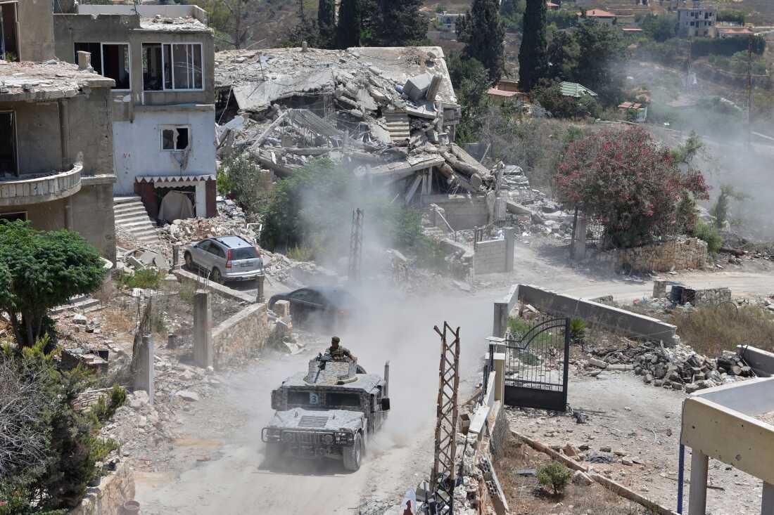 A Lebanese military vehicle drives past homes damaged during the war in the southern village of Zawtar al-Gharbieh, Lebanon, Monday, July 27, 2026.