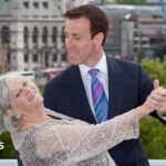 Ann Widdecombe dances with Anton du Beke in a ballroom pose with London skyline in background