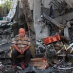 A Palestinian man rests amid debris at the site of an Israeli strike on a house in Gaza City, on July 30, 2026.