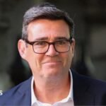 Andy Burnham pictured wearing a white shirt and dark suit