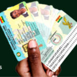 A hand fans out several Ghana Cards, showing the front and back of the national identity card
