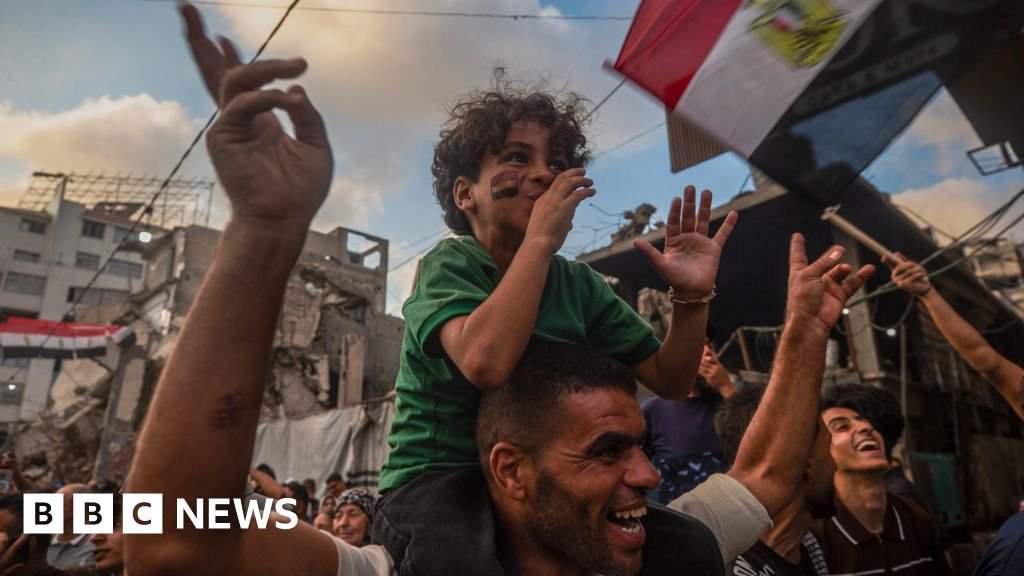 Boy sits on his father's shoulders