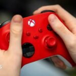 Hands holding a red Xbox controller