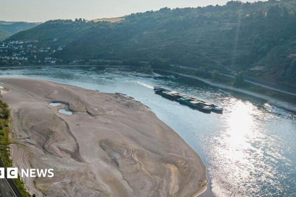 An aerial view as a cargo ship passes a huge exposed sandbar on the Rhine River