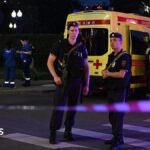Armed Moscow police stand guard in front of an ambulance near the scene of an explosion near the centre of the city.