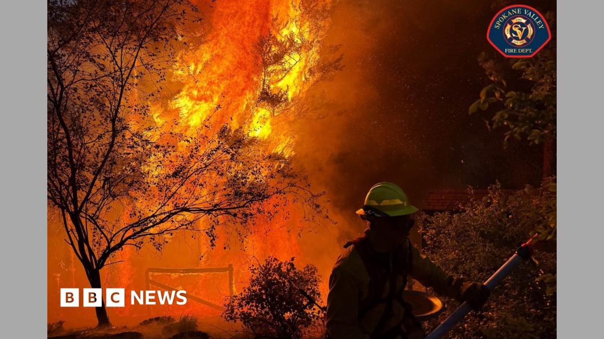 A member of the Spokane Valley Fire Department battles a fire northeast of Spokane, Washington